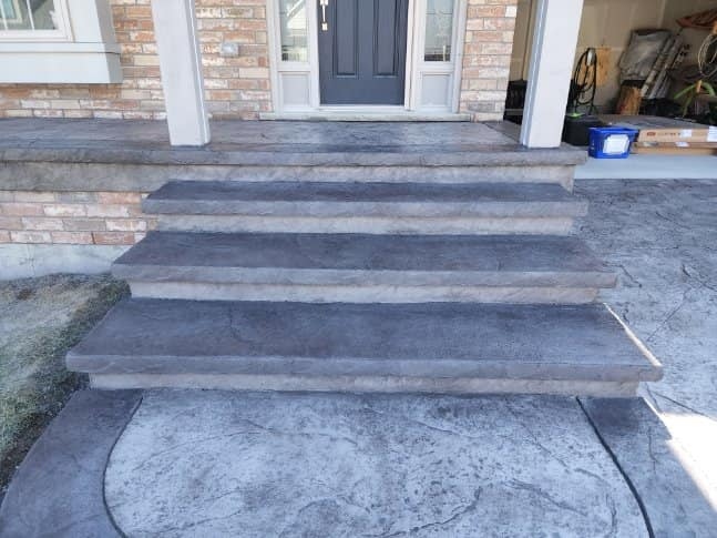 Wide dark stamped driveway with Canadian flag