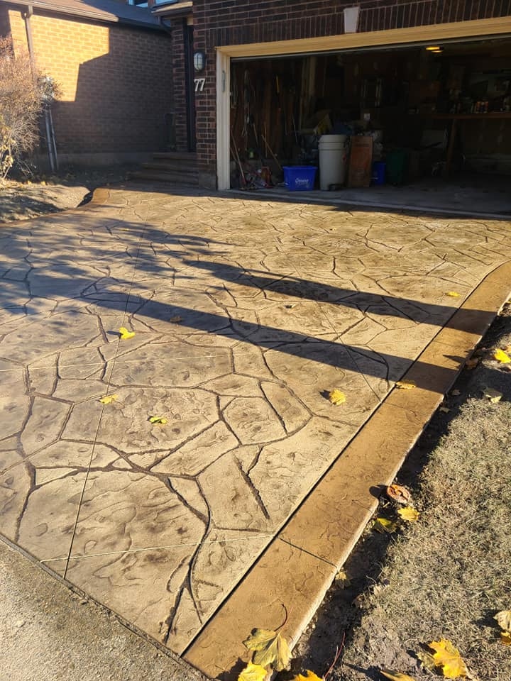 Flagstone-stamped driveway at angle, autumn leaves, warm tones