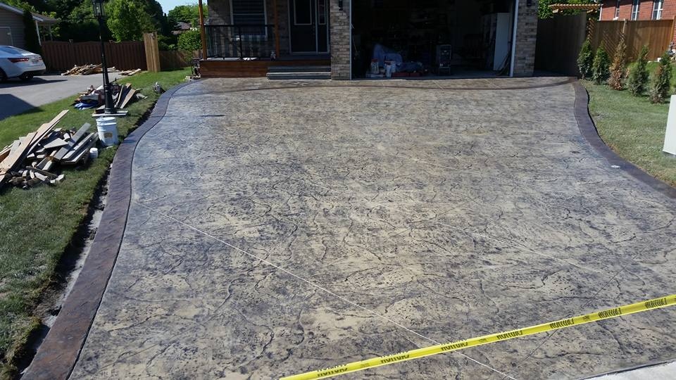 Flagstone stamped driveway full width view with brown curved border