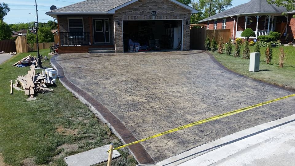 Wide flagstone stamped driveway with curved border, tan and brown tones