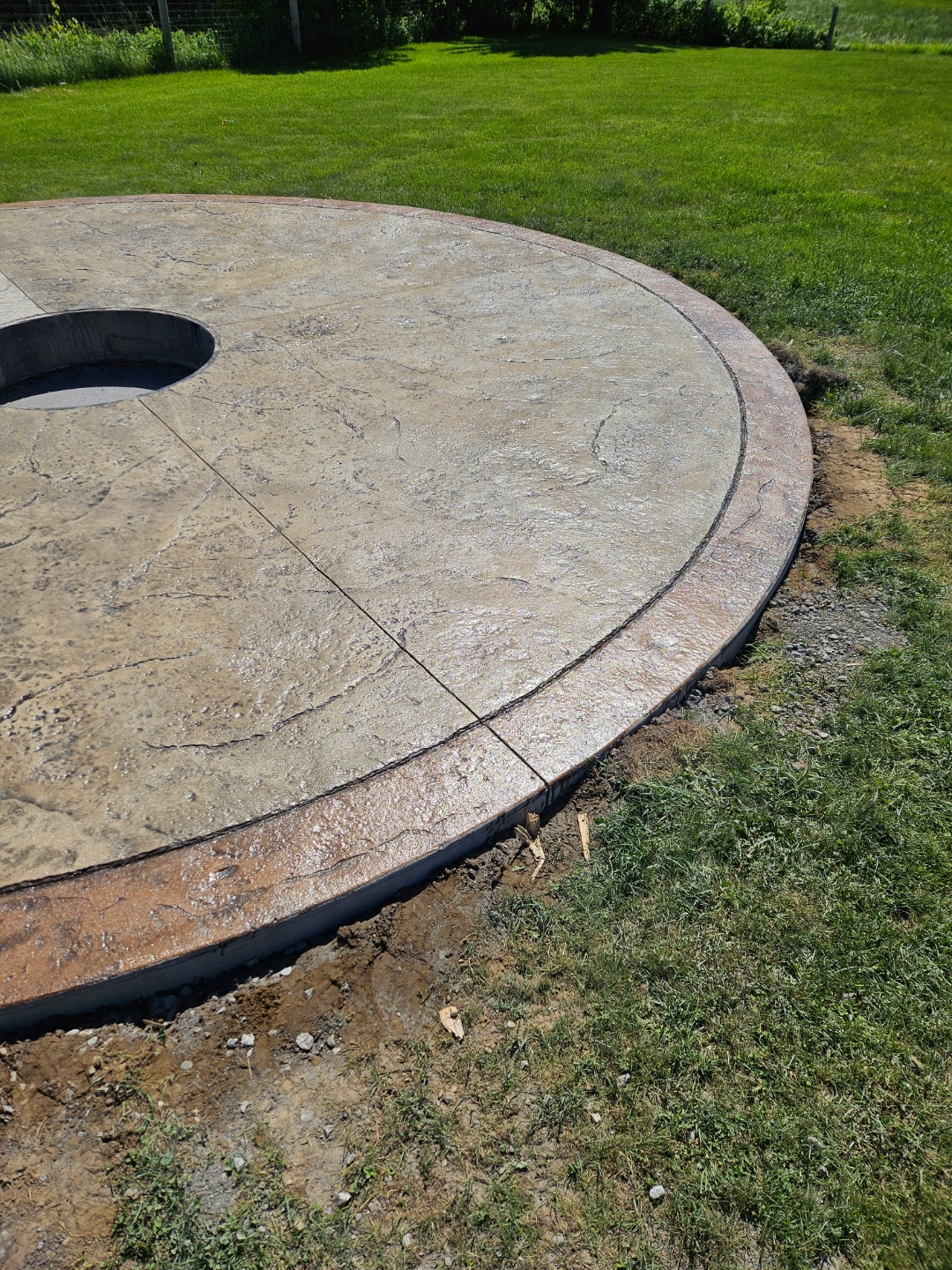Circular stamped concrete fire pit pad