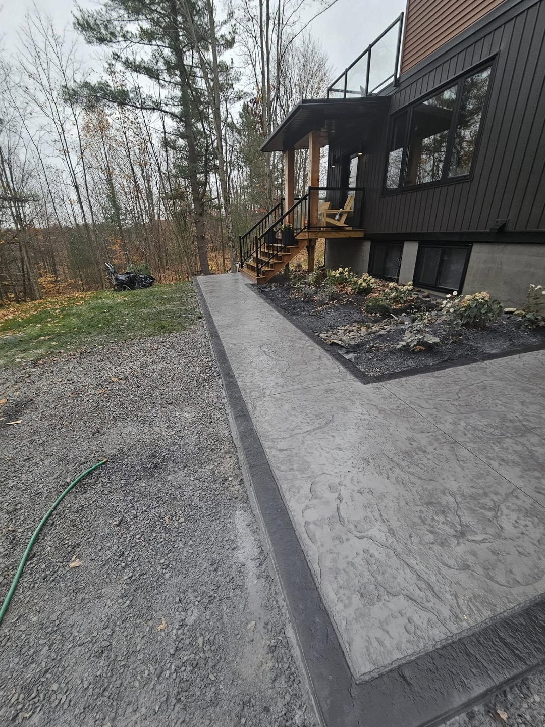 Stamped concrete patio beside modern cottage home