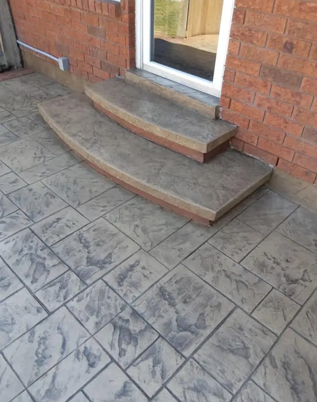 Stamped concrete patio with curved steps to back door