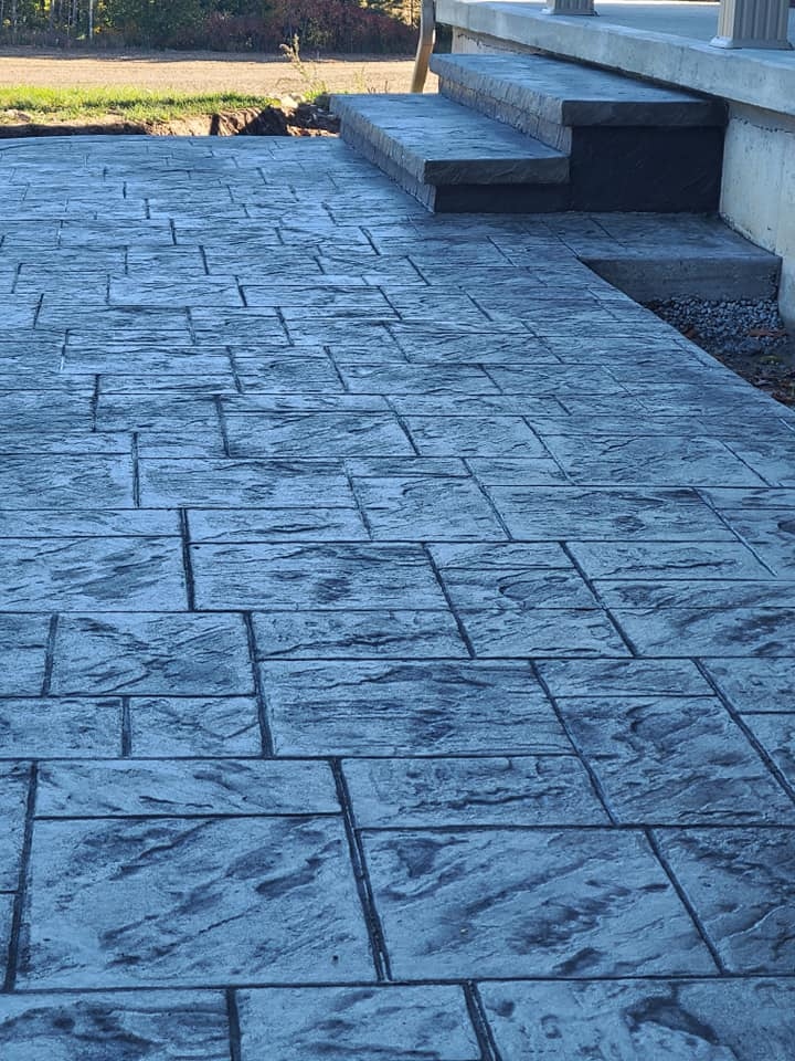 Angled view of grey stamped tile patio with steps