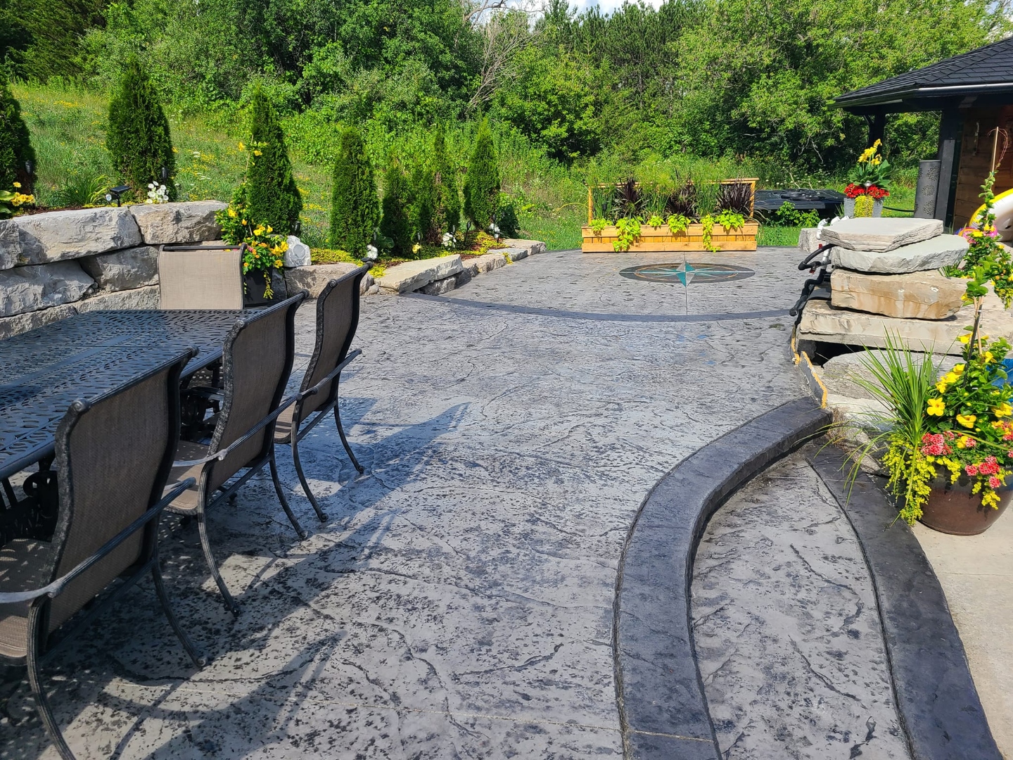 Pool deck with stamped border and smooth slab, stone retaining wall