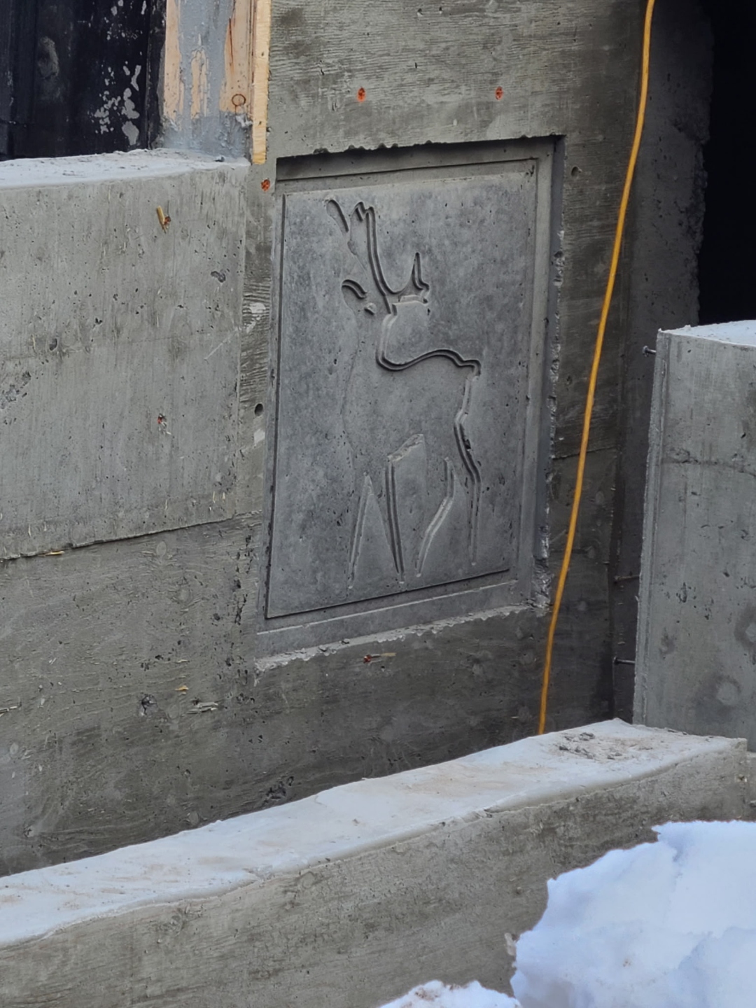 Custom deer carving embossed into concrete retaining wall