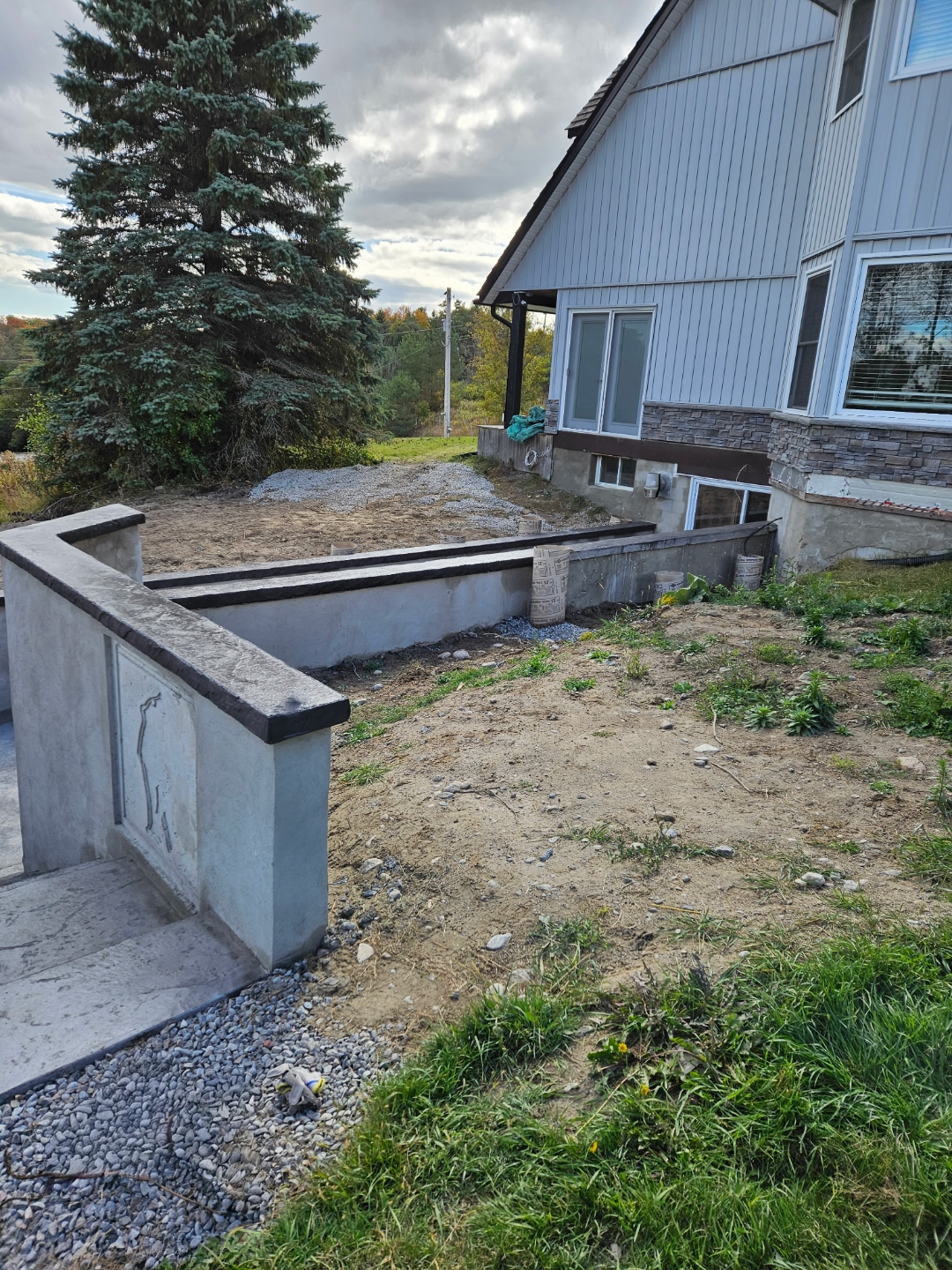 Concrete retaining wall with custom dog carving and dark cap