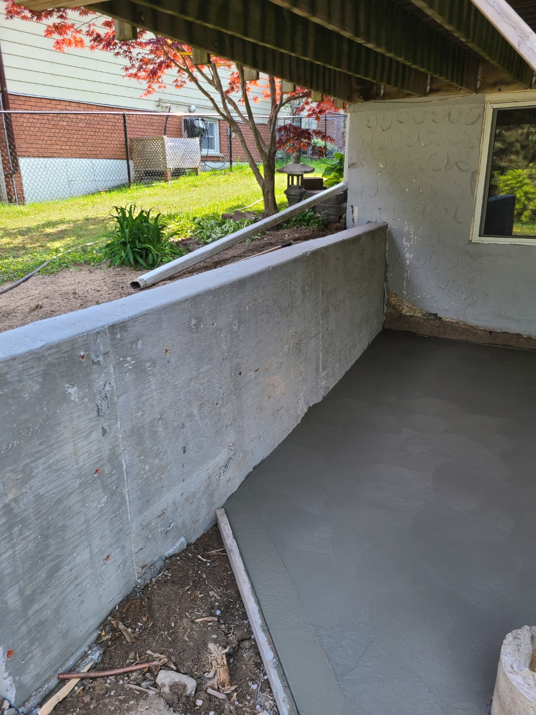 Finished concrete retaining wall with fresh slab pour