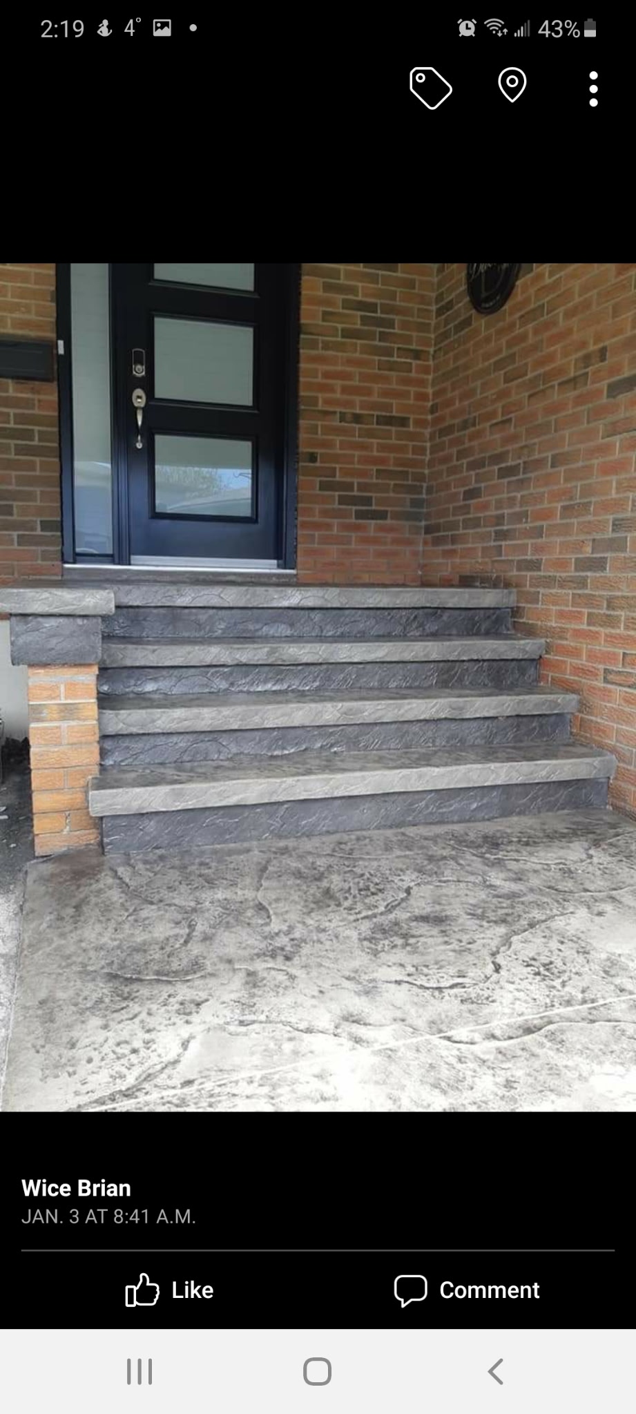 Dark stamped concrete stairs on brick home