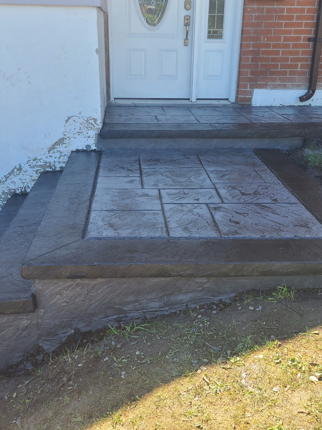 Dark stamped concrete front porch steps