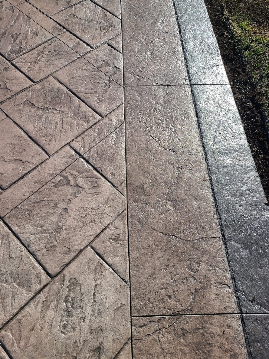 Close-up of herringbone meets flagstone edge detail, warm brown tones