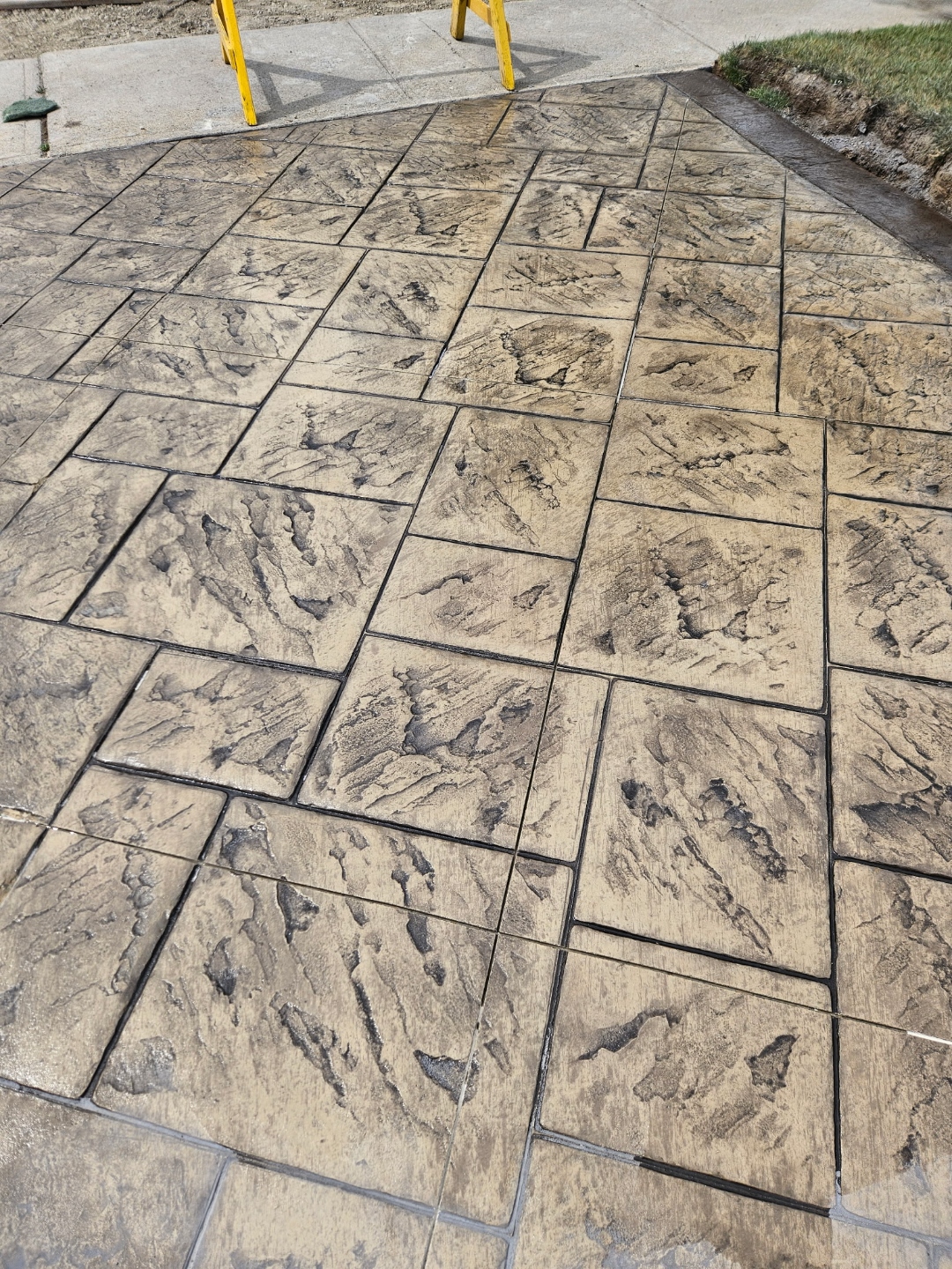 Stamped concrete herringbone pattern in tan, closeup