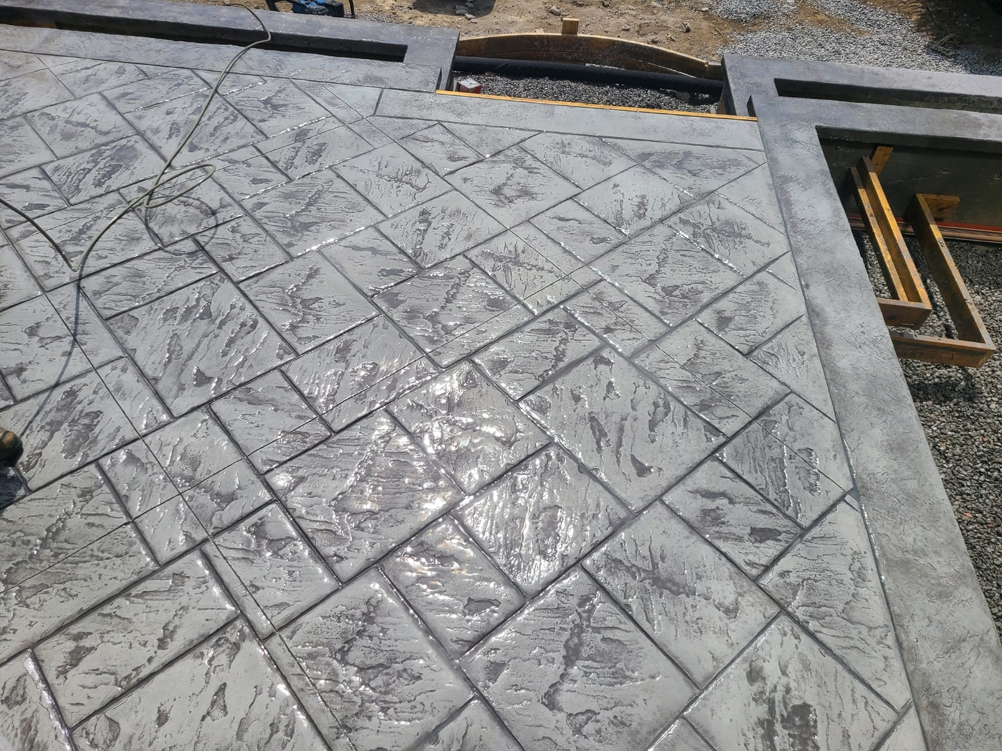 Close-up of large grey marble-look stamped tile in diamond pattern