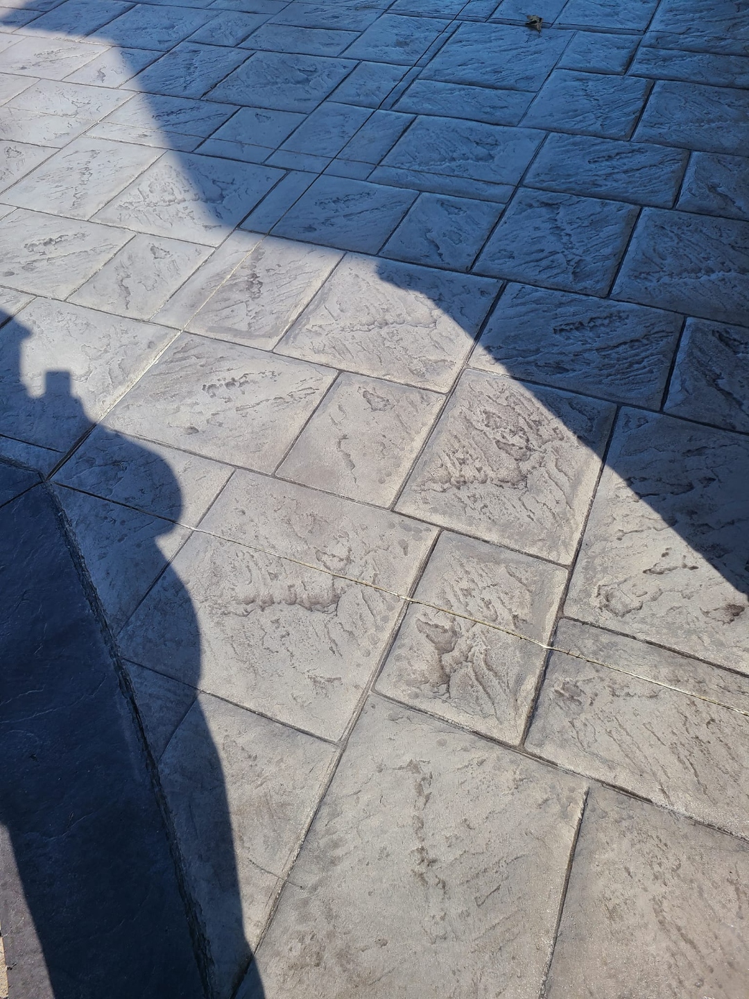 Stamped tile detail with dramatic shadow contrast, two-tone charcoal