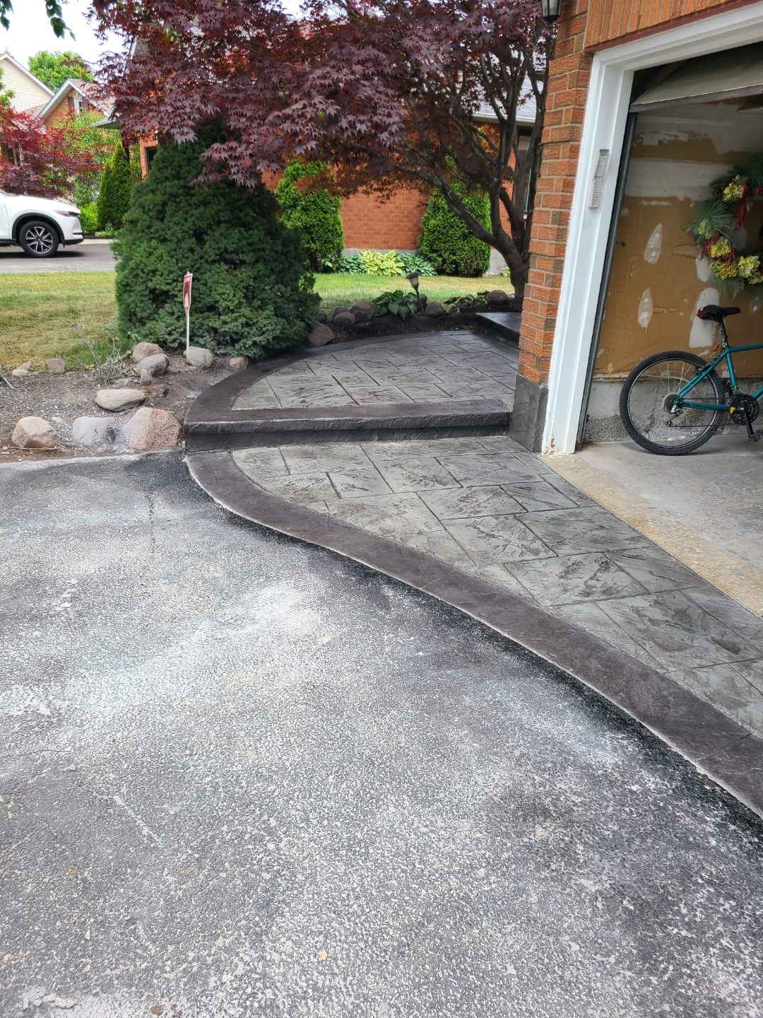Stamped concrete walkway beside asphalt driveway