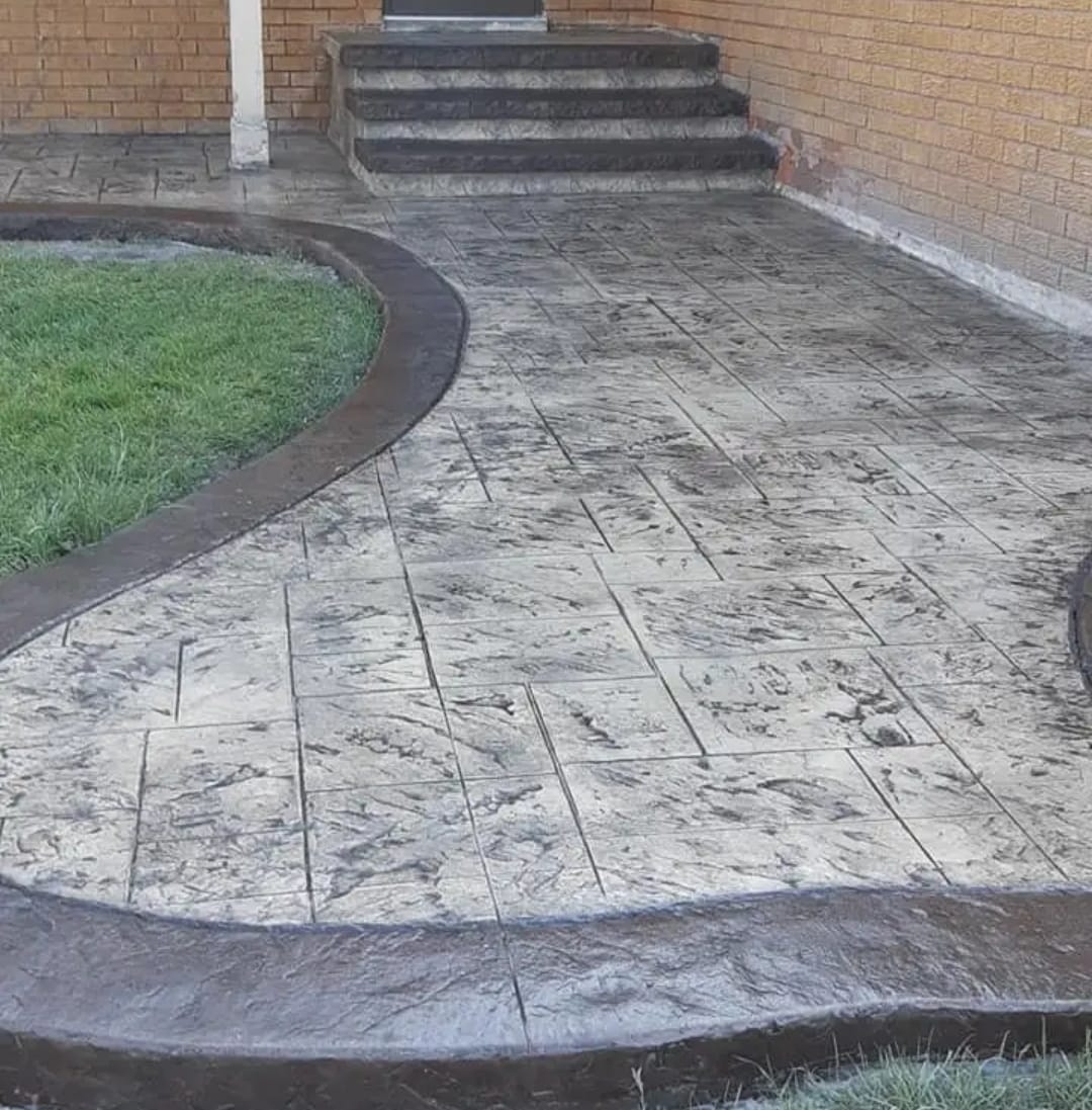 Curved front entrance stamped walkway with dark charcoal S-curve border