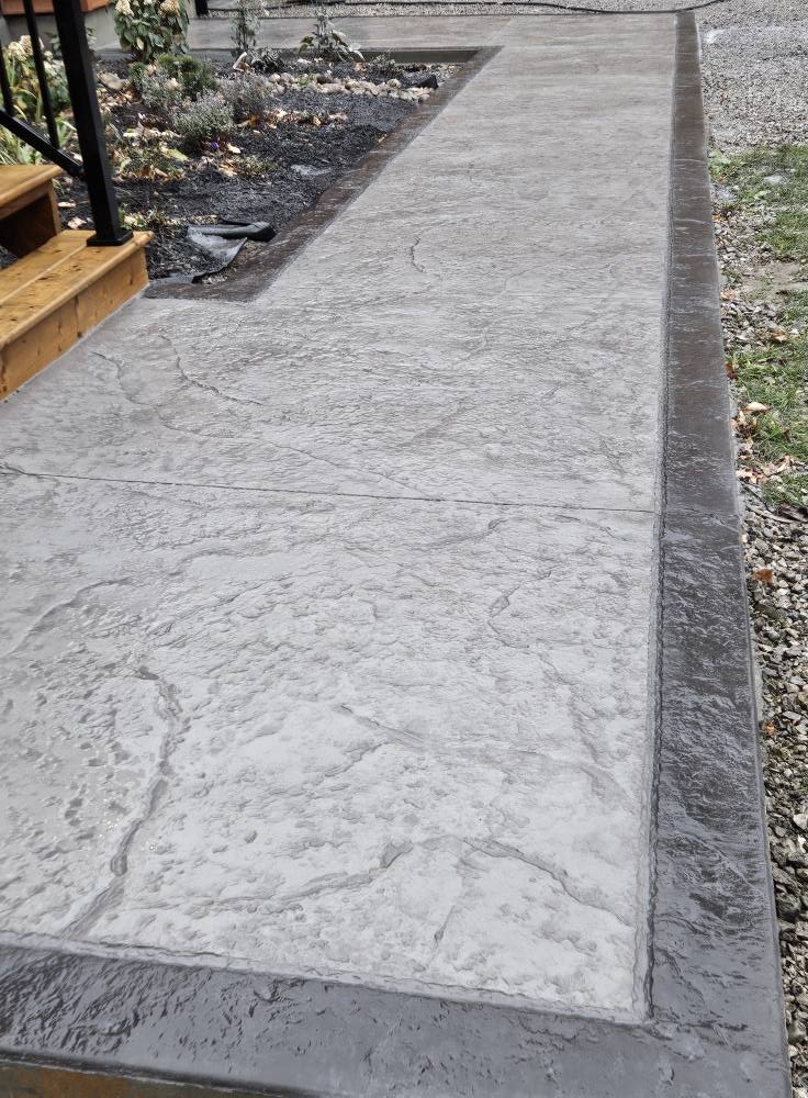 Grey stamped concrete walkway with dark border