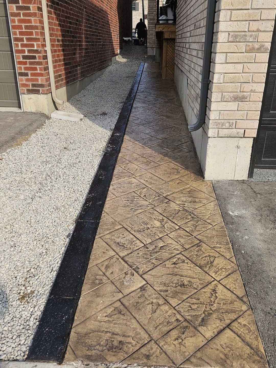 Narrow stamped herringbone side walkway between houses