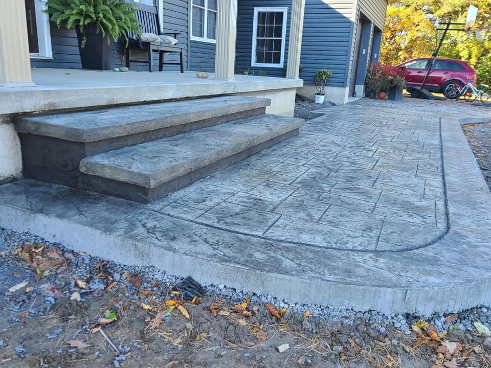 Grey stamped tile front steps and curved landing pad in autumn