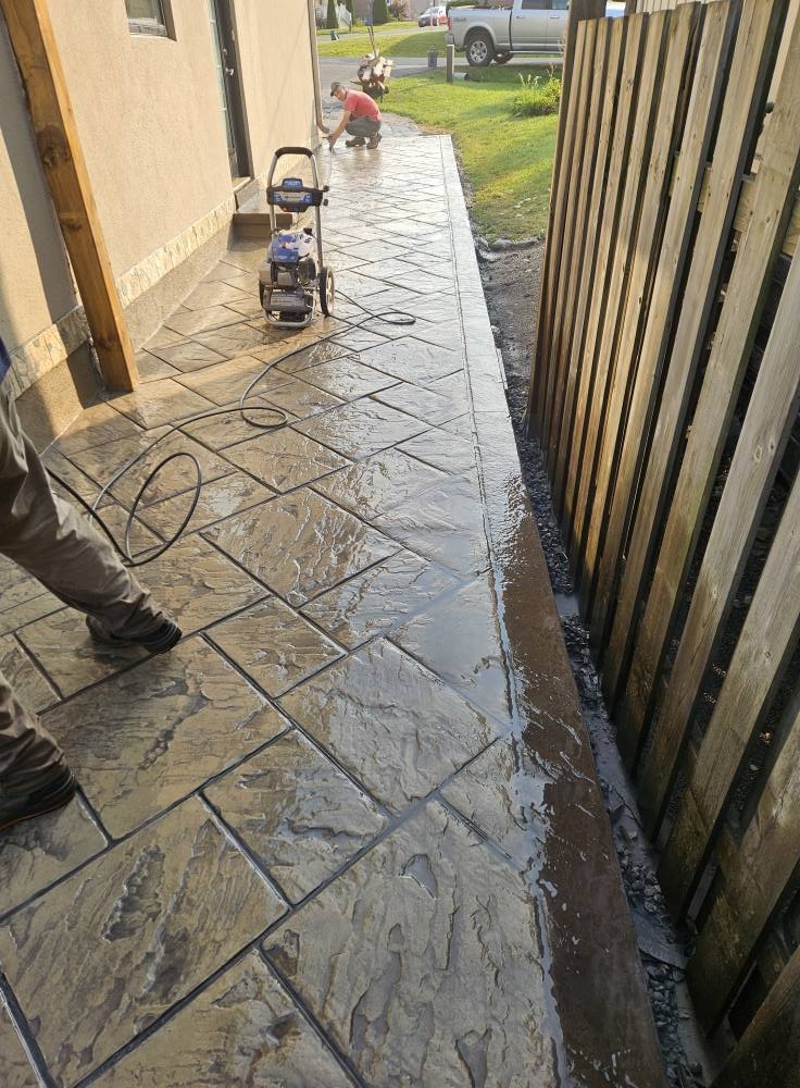 Stamped concrete walkway being sealed